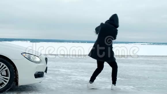 一个穿着黑色夹克的年轻人在一辆昂贵的白色汽车的背景上说唱视频的预览图