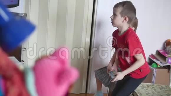 孩子们玩电子游戏控制台男孩和女孩在室内玩网络游戏视频的预览图