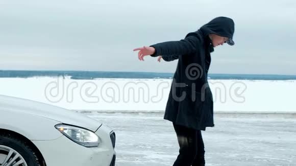 一个穿着黑色夹克的年轻人在一辆昂贵的白色汽车的背景上说唱视频的预览图