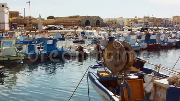 地中海码头上有小型渔船和远处行走的人视频的预览图