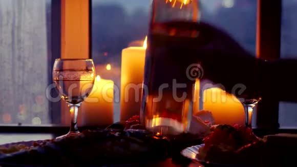 晚上在城市背景上用酒杯斟酒节日桌上放着美味可口的烤鱼4k视频的预览图