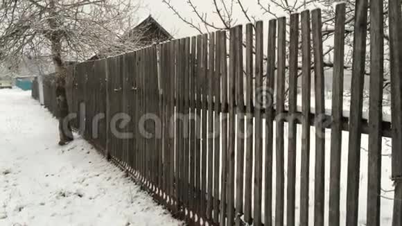 旧木栅栏背景下的雪视频的预览图