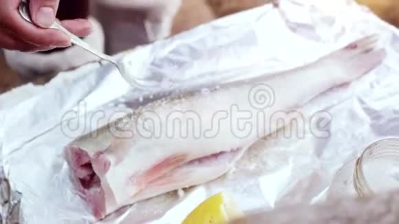 用柠檬和香草做鱼的过程用手在切割板上烹饪3840x2160视频的预览图