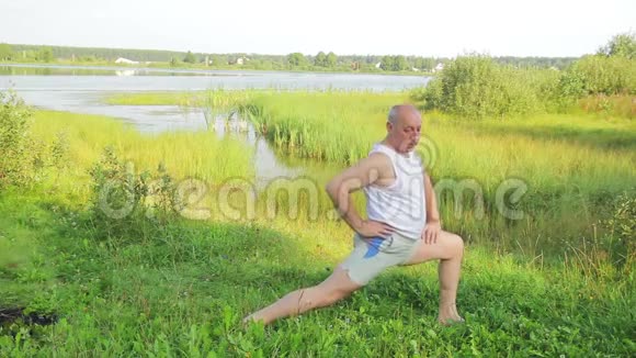 一位老人早上在湖边做伸展运动视频的预览图