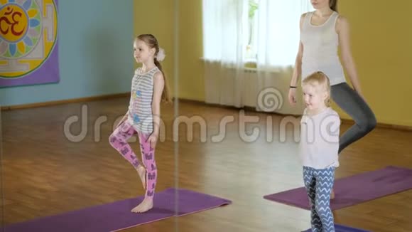 妈妈和女儿们一起在健身室做瑜伽视频的预览图