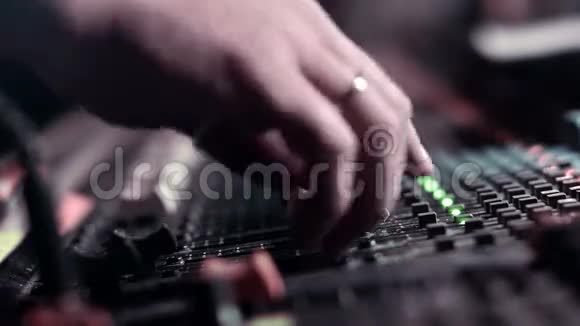 音频工程师在现场活动期间在他的混合控制台上调整着色器视频的预览图
