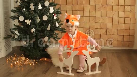 在圣诞树附近穿着狐狸套装的小女孩视频的预览图