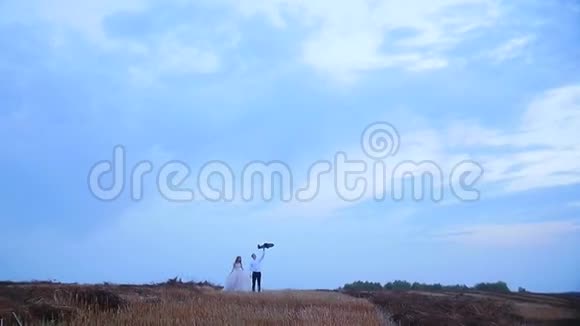 一个男人和一个女孩在草地上散步日落时分的浪漫视频的预览图
