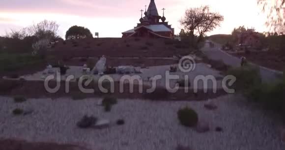 日落时小城市木制教堂的鸟瞰图古老风格的基督教圣殿4K视频的预览图