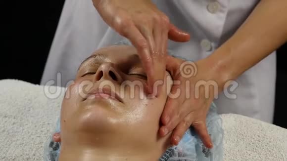 水疗沙龙塑料面部按摩妇女享受专业按摩治疗师的服务慢动作视频的预览图