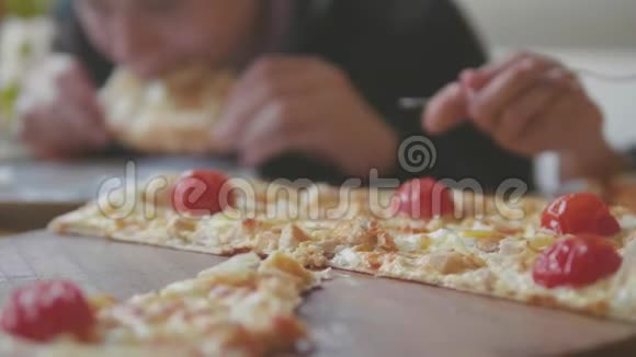男孩和女孩在咖啡厅慢动作视频中吃披萨孩子们吃比萨饼吃美味的比萨饼生活方式公司视频的预览图