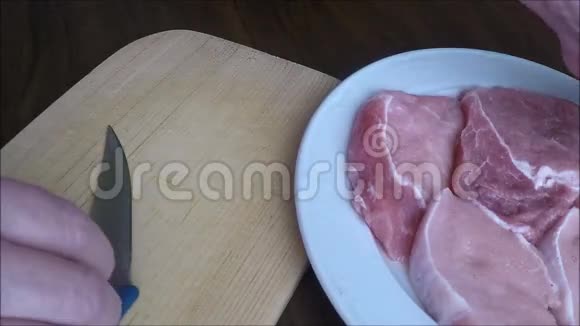 女性手在砧板上切肉的特写视频的预览图