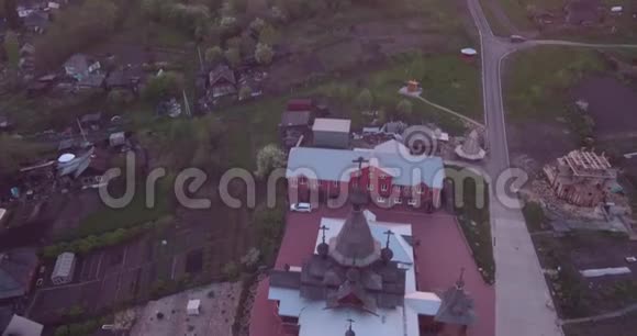 日落时小城市木制教堂的鸟瞰图古老风格的基督教圣殿4K视频的预览图