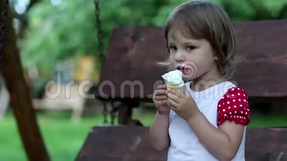 小女孩坐在长凳上吃冰淇淋视频的预览图