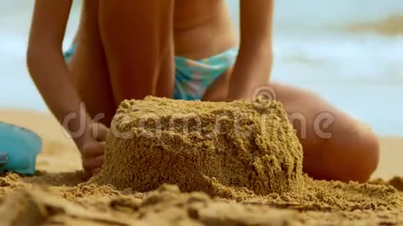 女孩在热带海滩上建造了一座沙堡特写视频的预览图
