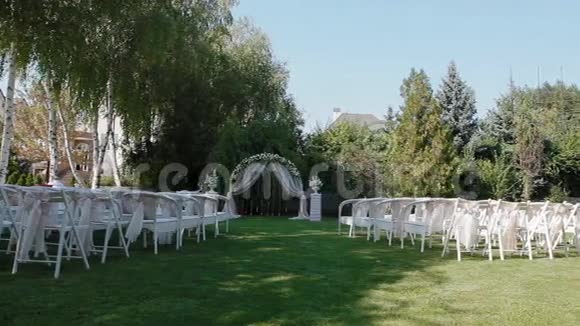 带有拱门和白色椅子的婚礼装饰视频的预览图