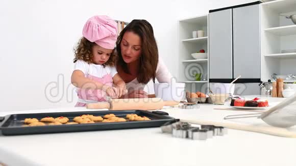 可爱的女孩和她妈妈一起烘焙视频的预览图
