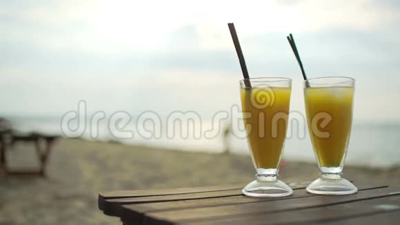 在海边的木桌上放两杯鸡尾酒视频的预览图