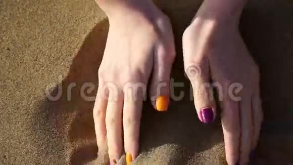 一个在海滩上散步拿着沙子的摄影妇女视频的预览图
