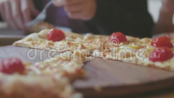 男孩和女孩在咖啡厅慢动作视频中吃披萨孩子们吃比萨饼吃美味的比萨饼人的公司视频的预览图