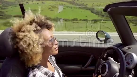 戴太阳镜开车的年轻女子视频的预览图