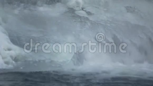 冬天落水冰晶下流动的水特写视频的预览图