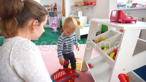 妈妈和她的小男孩在房间里玩里面有五颜六色的积木球厨房视频的预览图