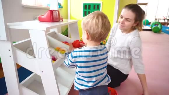 妈妈和她的小男孩在房间里玩里面有五颜六色的积木球厨房视频的预览图