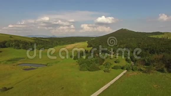 空中美丽的绿草山景观中的道路视频的预览图