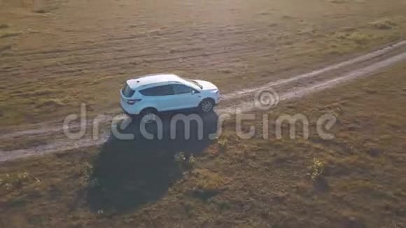 在夏季草地上驾车穿过马路的空中景色视频的预览图
