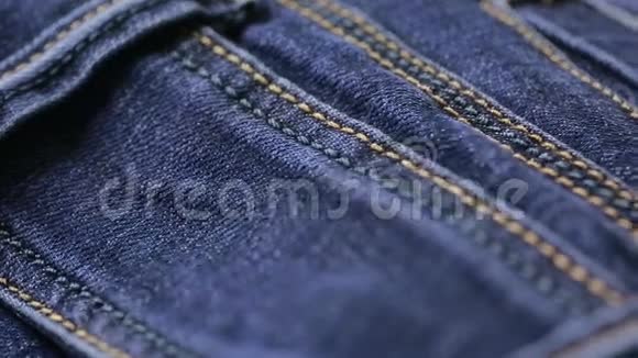 蓝色牛仔裤的质地可以用作背景牛仔布的特写视频的预览图