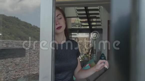 漂亮的红发女孩穿着优雅的衣服在她豪华的公寓里视频的预览图