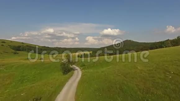 空中美丽的绿草山景观中的道路视频的预览图