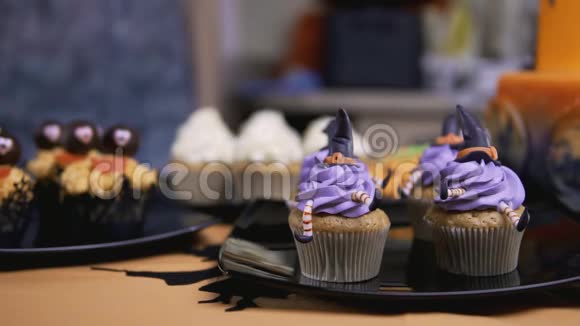 用糖霜帽和腿装饰纸杯蛋糕像女巫一样的松饼万圣节概念视频的预览图