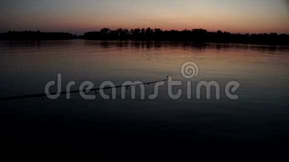 钓竿等待在背景黄昏夕阳的河水中咬人视频的预览图