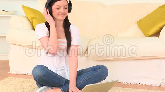 女人在笔记本电脑上听音乐和冲浪视频的预览图
