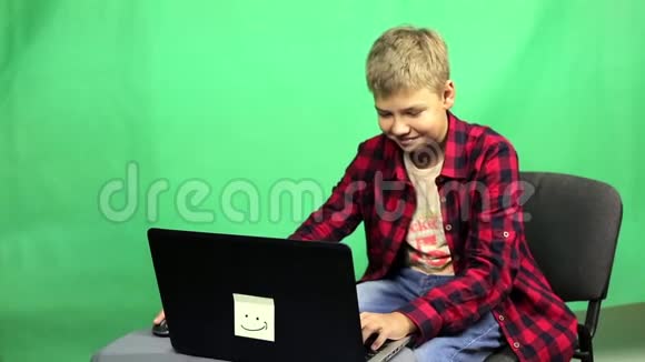小男孩博主在绿色背景下录制视频视频的预览图