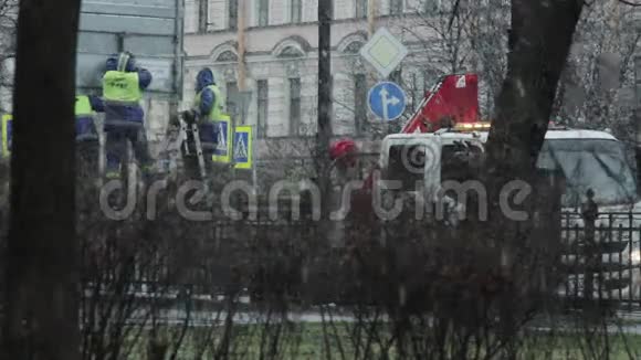 工人在雨中修理街道标志视频的预览图