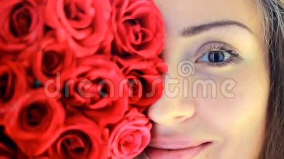 一位美丽的年轻女子用红玫瑰特写视频的预览图