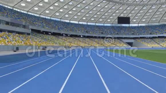 空中拍摄在一个巨大的现代空荡荡的体育场内在轨道线上飞行视频的预览图