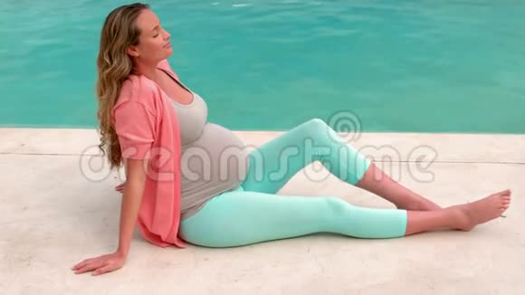 坐在游泳池附近的孕妇视频的预览图