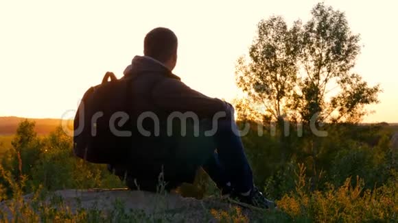 一个背着背包的男人在明亮的天空日落时的剪影太阳下山了旅行概念旅游旅行性质视频的预览图