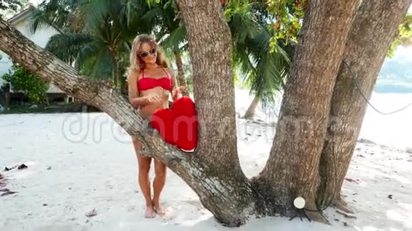 穿着红色比基尼的漂亮女人住在海滩上视频的预览图