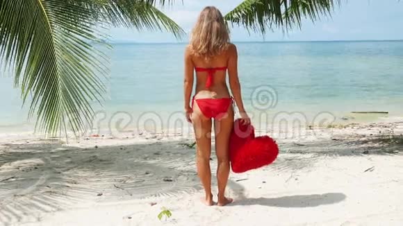 穿着红色比基尼的漂亮女人住在海滩上视频的预览图