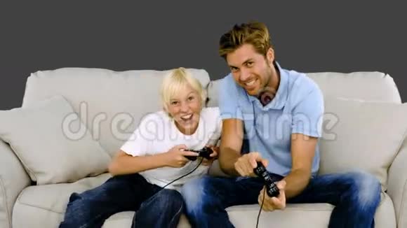 父亲和儿子在灰色背景下玩电子游戏视频的预览图