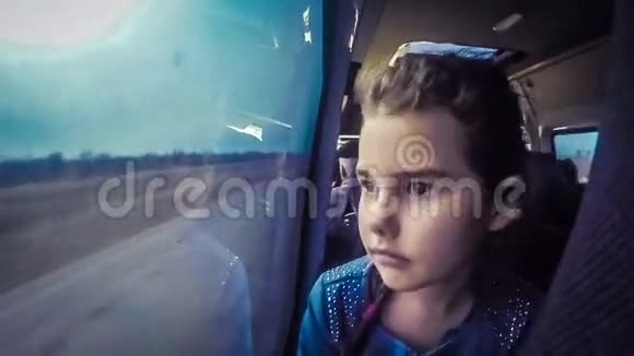 十几岁的女孩坐在车里看着外面视频的预览图