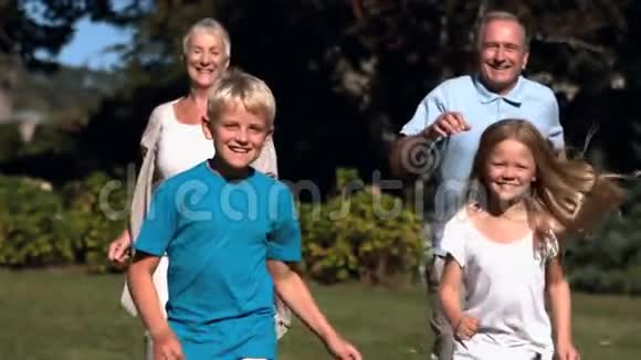 和祖父母一起在公园里跑步的孙子视频的预览图