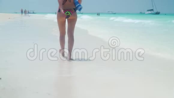 光脚女孩在海边沙滩上散步视频的预览图