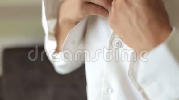 一位年轻的商人扣上衬衫的特写视频的预览图