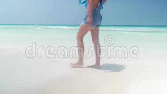 光脚女孩在海边沙滩上散步视频的预览图